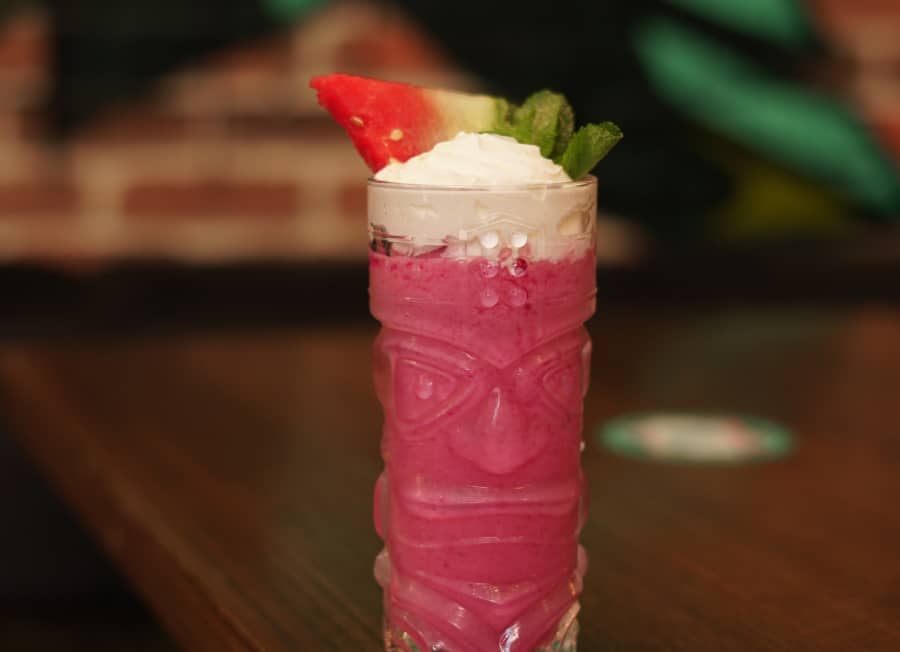 Pink drink with watermelon in a hawaiian glass